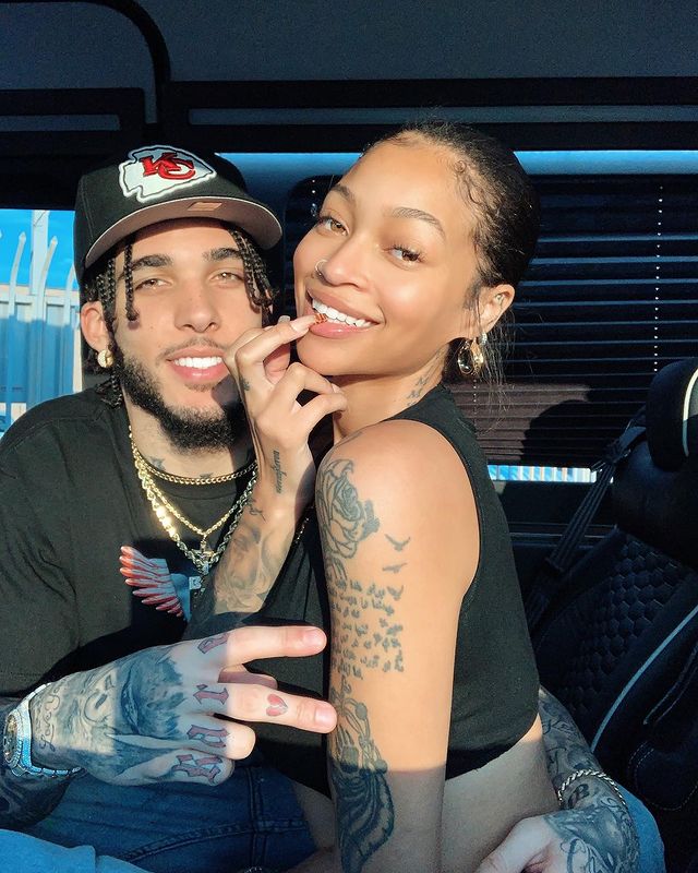 LiAngelo in a hat and black dress with his girlfriend Evoni Barbour.